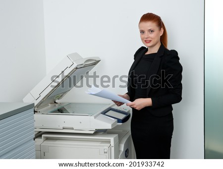 attractive red hair business woman working on office printer machine