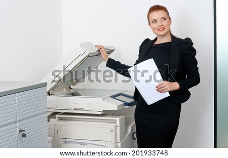 attractive red hair business woman working on office printer machine
