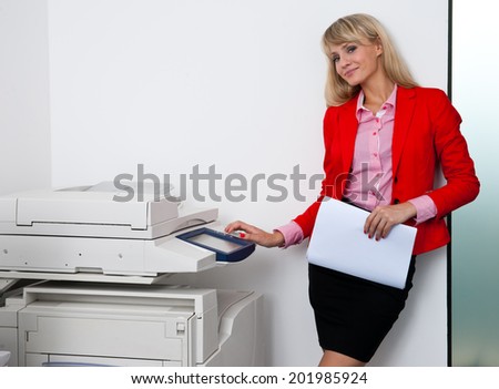 attractive blond business woman working on office printer machine