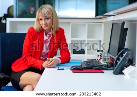 attractive blond business woman in office cubicle workspace