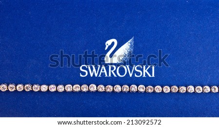 ZAGREB , CROATIA - AUGUST 24 , 2014 : Swarovski jewelry brand logo next to necklace close up , product shot