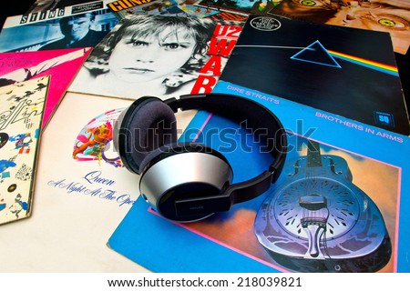 ZAGREB , CROATIA - SEPTEMBER 17 , 2014 -  Philips headphones on various old vinyl LP records on black background, product shot