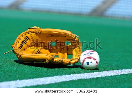 ZAGREB , CROATIA - 13 AUGUST 2015 -  official Major League Baseball ball and glove on the green field , product shot