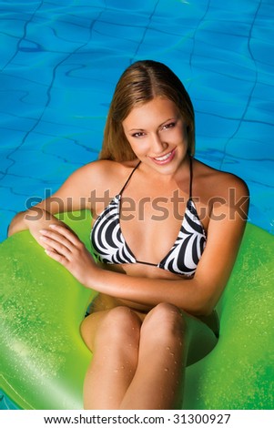 young woman on green pool float