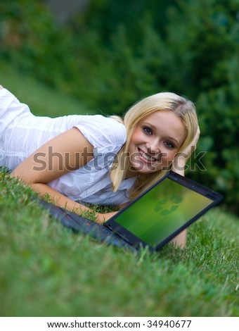 girl and laptop with recycle sign on the grass