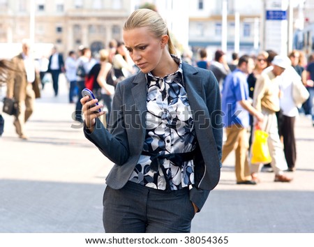 sophisticated woman with mobile phone in town square