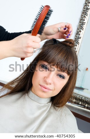 woman in hair salon having treatment with hair brush