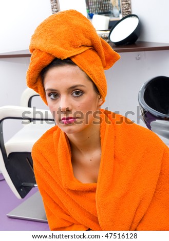 woman in hair salon with orange towel on her head