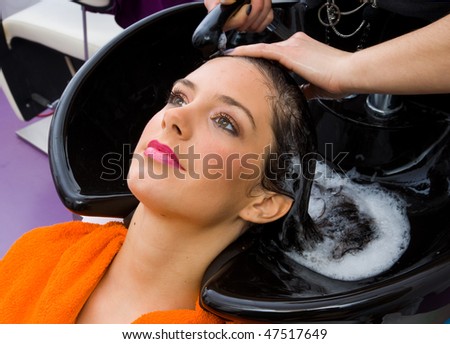hair stylist washing woman head in hair salon