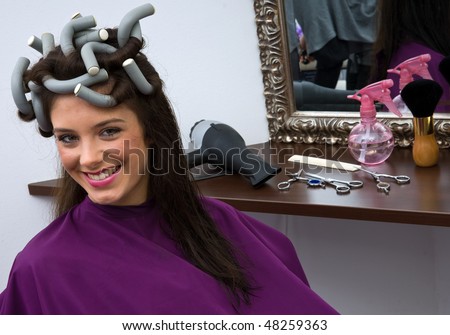 woman in hair salon with curlers on her hair