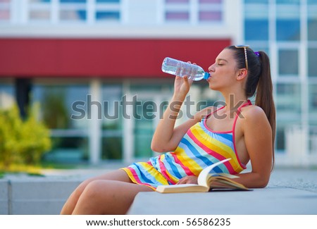 young woman drinking from water bottle