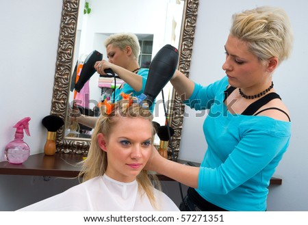 hair stylist work on woman hairstyle in salon