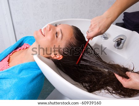 stylist brushing woman hair in salon pool