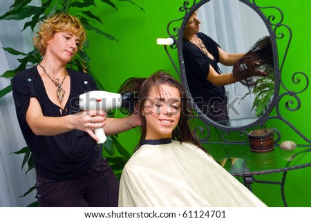 stylist working with hair dryer in salon