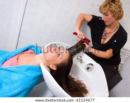 stylist brushing woman hair in salon pool