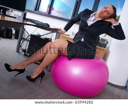 woman in office stretching on pilates ball