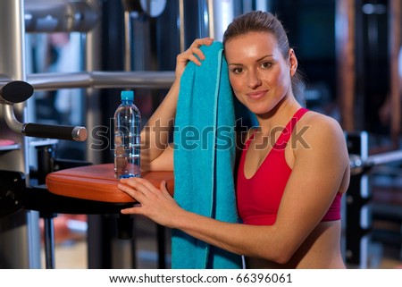 woman in gym with water and towel