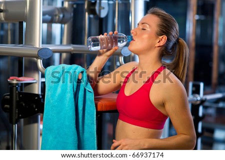 woman in gym drink water after exercise