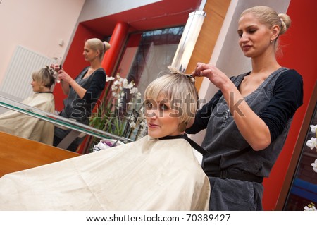 stylist work on woman hair in salon