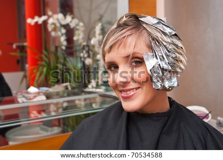 woman with coloring foil on her hair in salon
