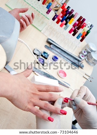woman in polishing finger nails treatment in manicure salon