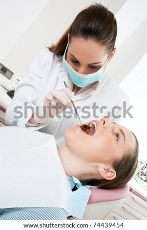 dentist examine woman teeth with mirror