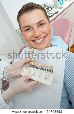 woman in dentist office choosing dental cover for her teeth