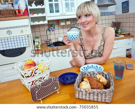 woman drinking coffee and eat breakfast at kitchen table