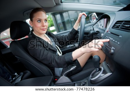 woman changing radio station while driving car