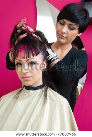 stylist making hair style to interesting teen girl