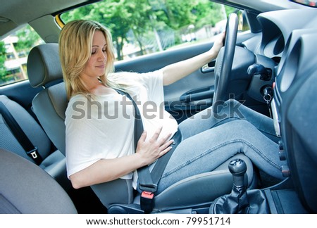 pregnant woman driving with safety belt on in the car