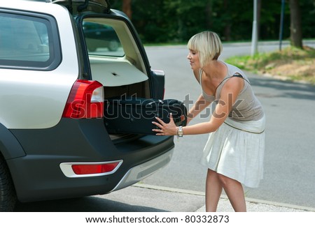 woman putting baggage to car trunk