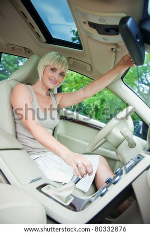 woman sitting in drivers seat of her luxury car