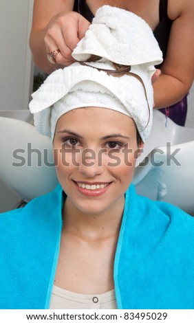 woman in hair salon with towel on her head