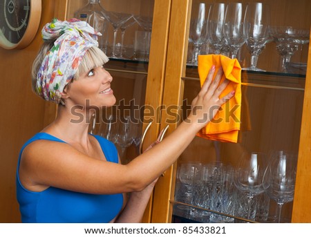 attractive woman cleaning and dusting at her home
