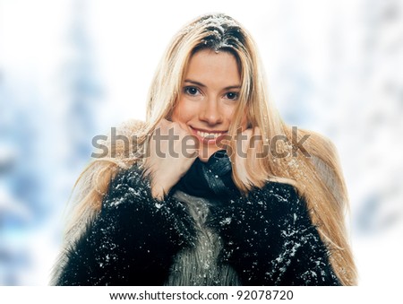 attractive woman in winter clothes covered with snow