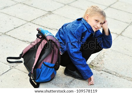 schoolboy with backpack does not want to go back to school