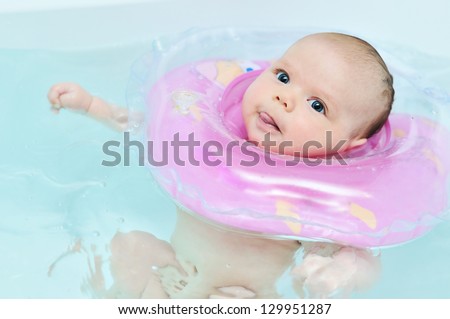 swimming baby in the bath  showing tongue