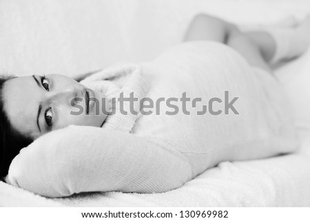 pretty pregnant woman laying on the sofa in black and white