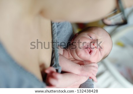 mother holding and calming down her newborn baby