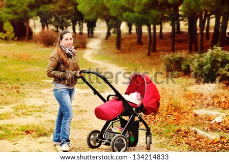 woman with stroller  walking in the fall park