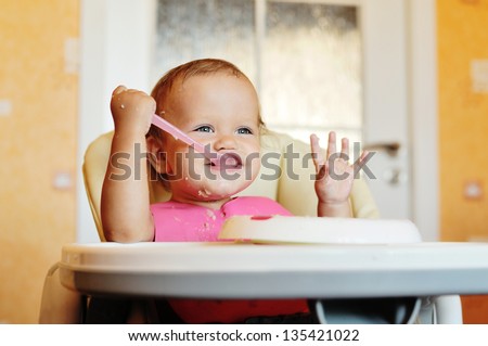laughing eating baby girl with dirty face