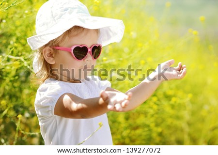 toddler girl enjoying summer light in rape field