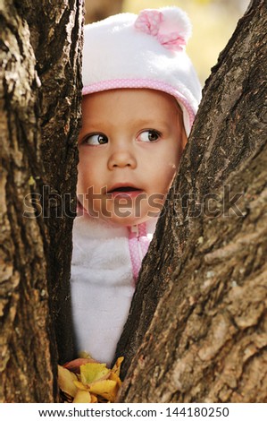 peek-a-boo  - toddler girl hiding between trees