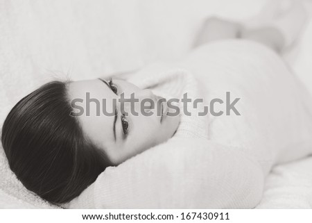 pretty pregnant woman laying on the sofa in black and white