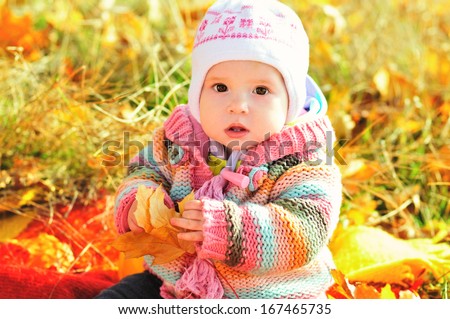 baby in fall time sitting with leaf