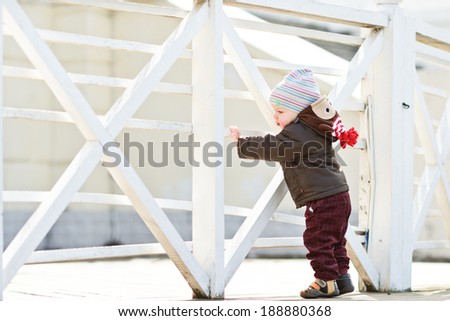 first steps of baby boy near the fence