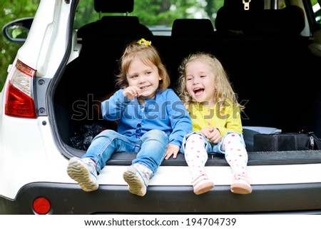 laughing toddler girls sitting in the car