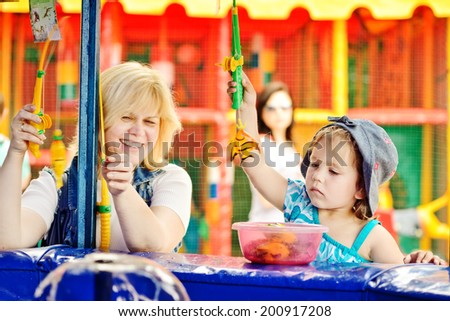 funny fishing of mother and daughter in amusement park