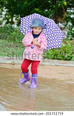 Adorable toddler girl at rainy day in summer